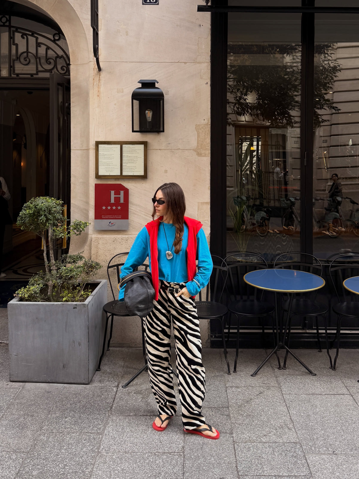Front view of black-and-cream zebra print relaxed wide-leg trousers styled with a blue top